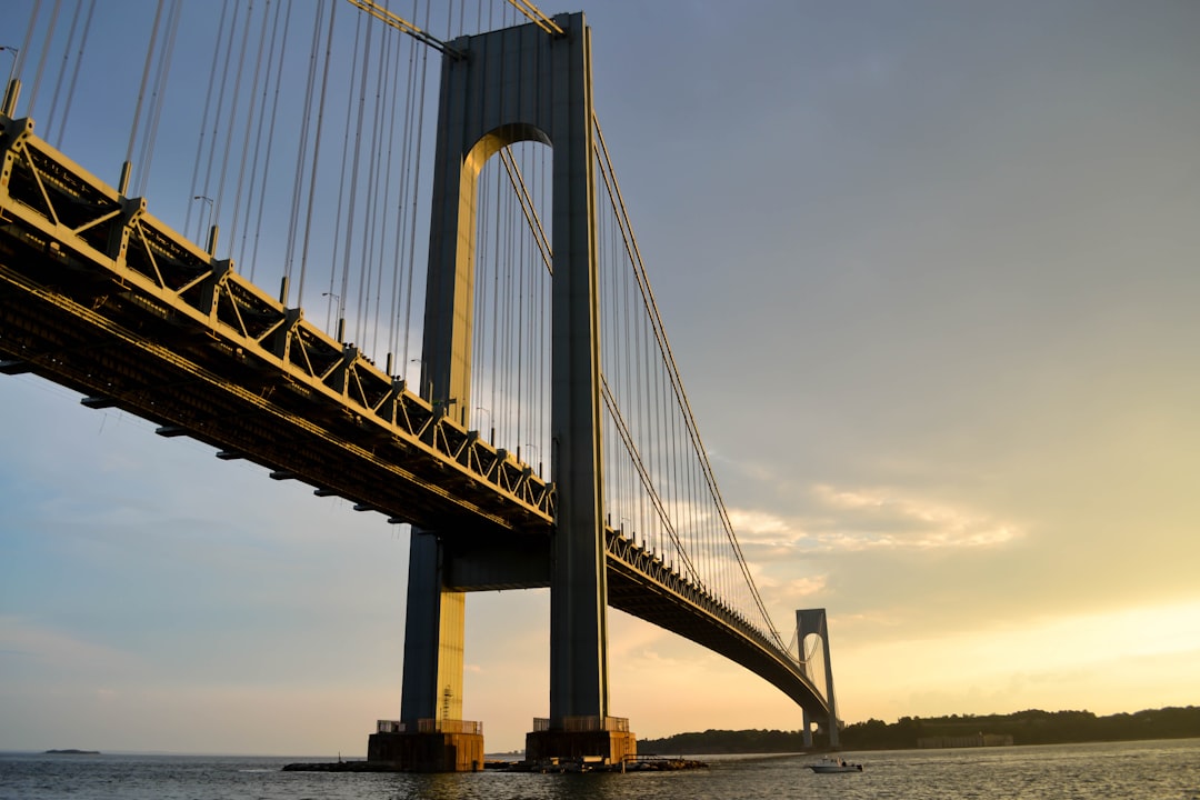 gray metal bridge across body of water,