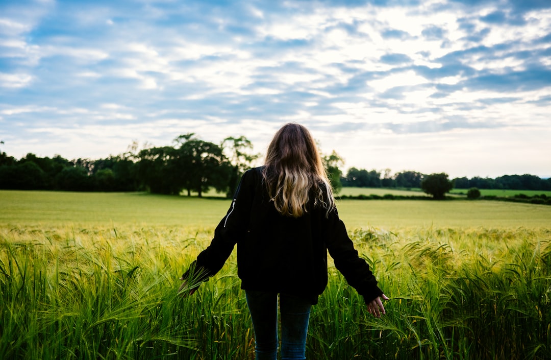 woman walking on grass field during daytime