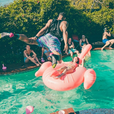 A man diving into a pool at a party.