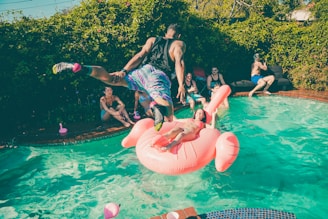 A man diving into a pool at a party.