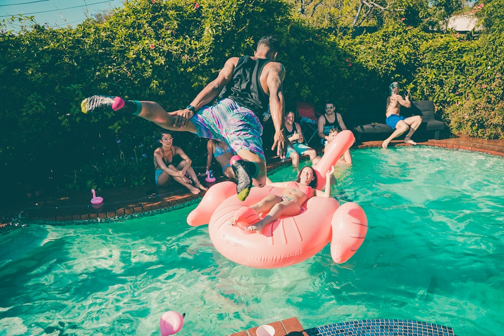 Um homem mergulhando em uma piscina em uma festa.