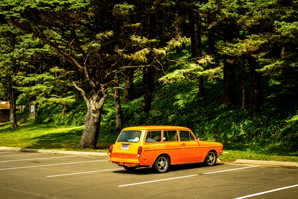 an orange car is parked in a parking lot