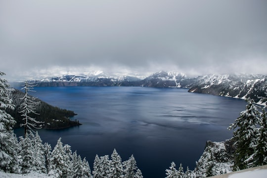 body of water surrounded by mountain covered with fog landscape photo in Crater Lake United States
