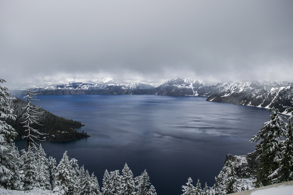 body of water surrounded by mountain covered with fog landscape photo