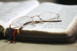 Senior health care book resting beside a cup of herbal tea and reading glasses.