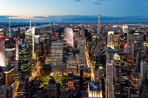 A bustling urban skyline with smart buildings lit up at dusk.