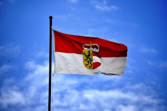 white and red flag on top of flagpole during daytime