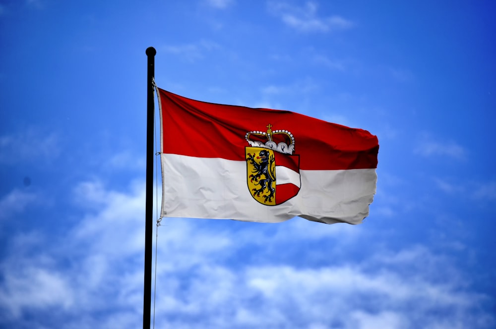 white and red flag on top of flagpole during daytime