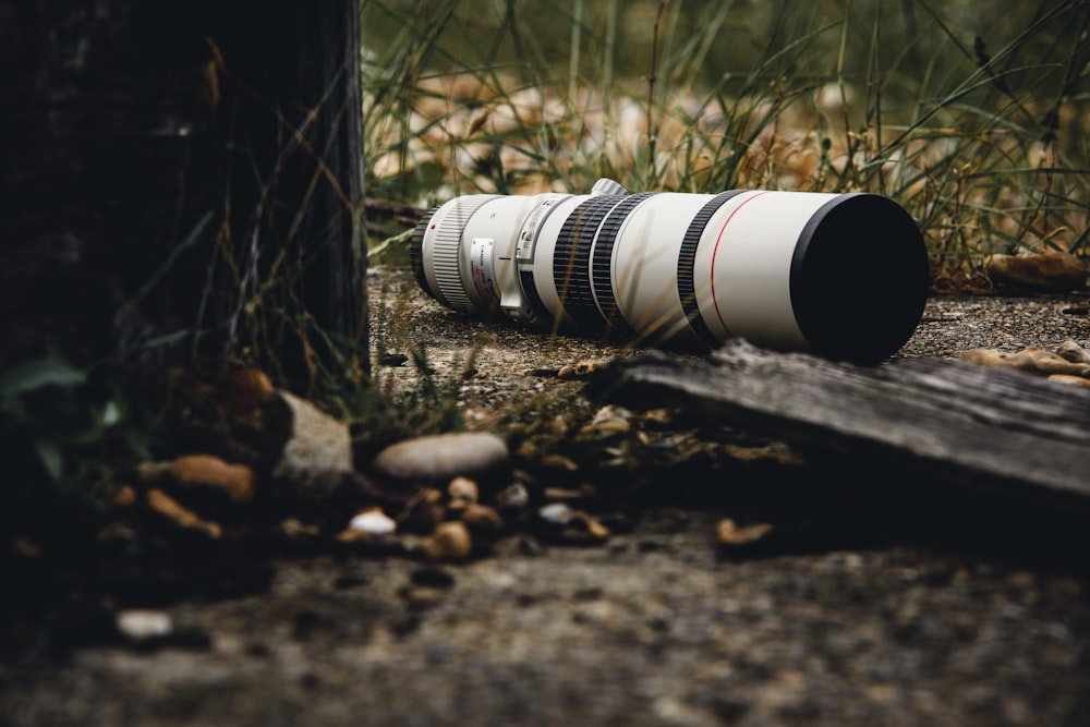 white and black camera lens on ground during daytime