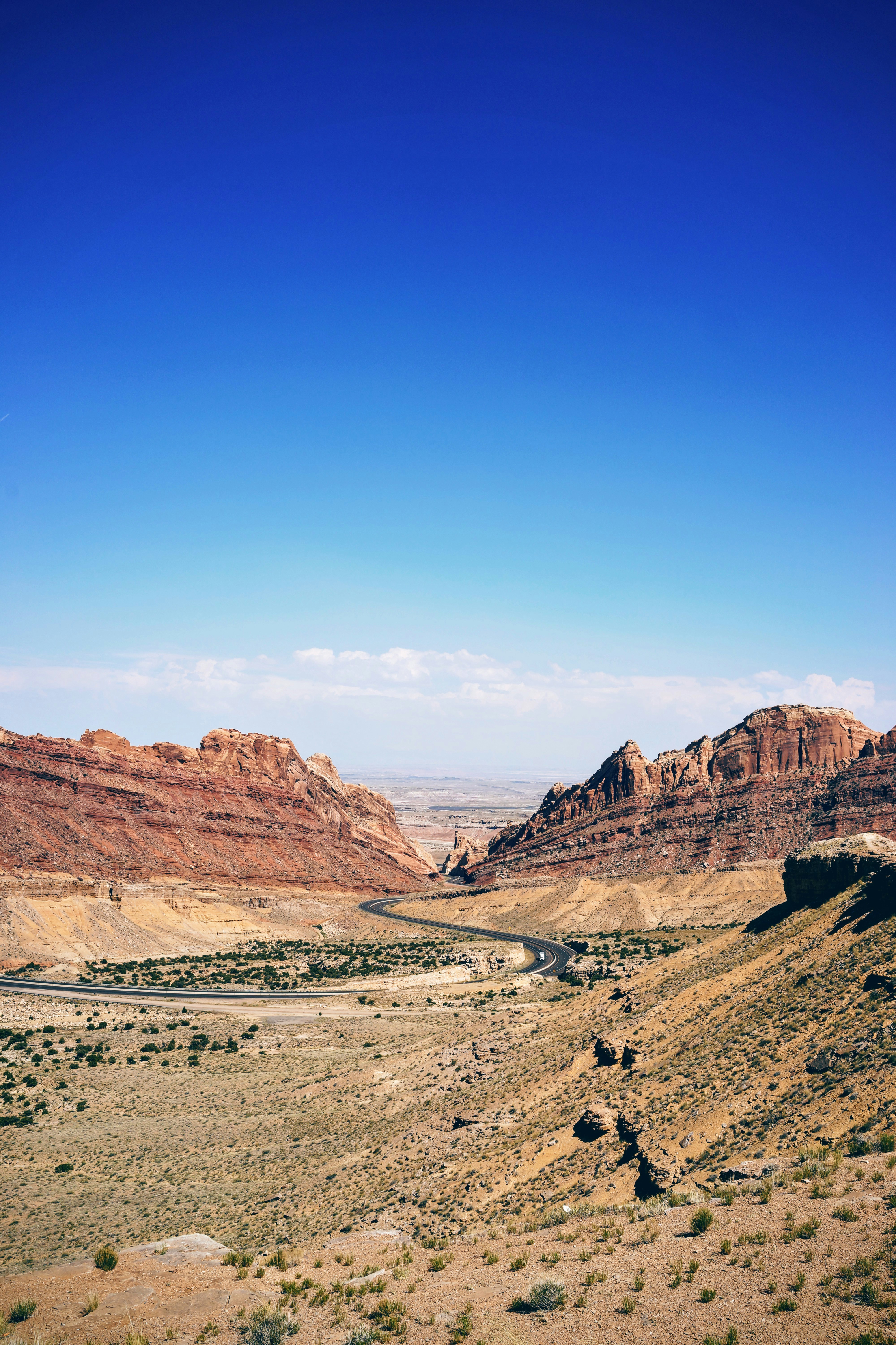 Highway road down the valley between mountains on a dry summer day at Spotted Wolf canyon