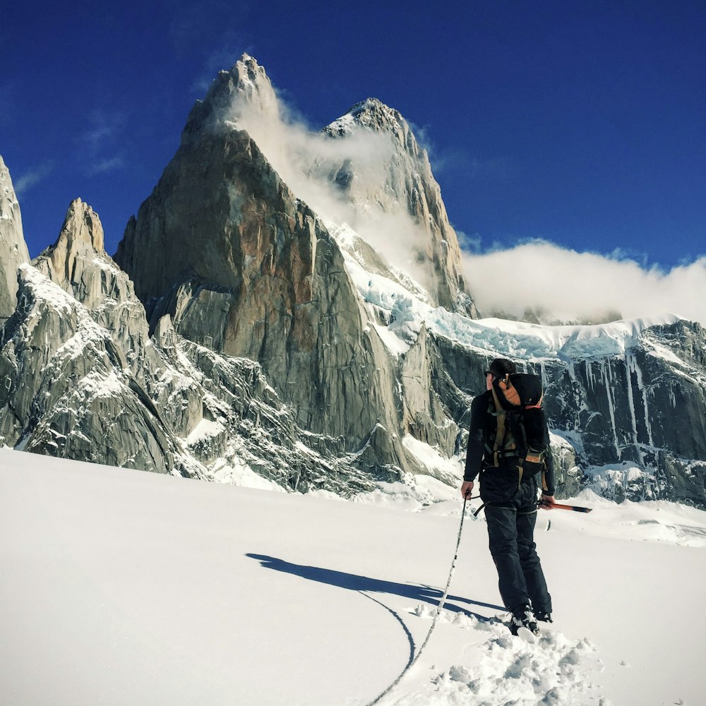 persona che cammina sul nevaio vicino alla montagna