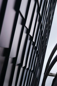 Close-up of a modern building facade with geometric patterns and soft shadows.