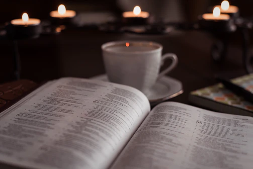 Cozy ritual setup featuring candles, tea, and the workbook open on a wooden table.