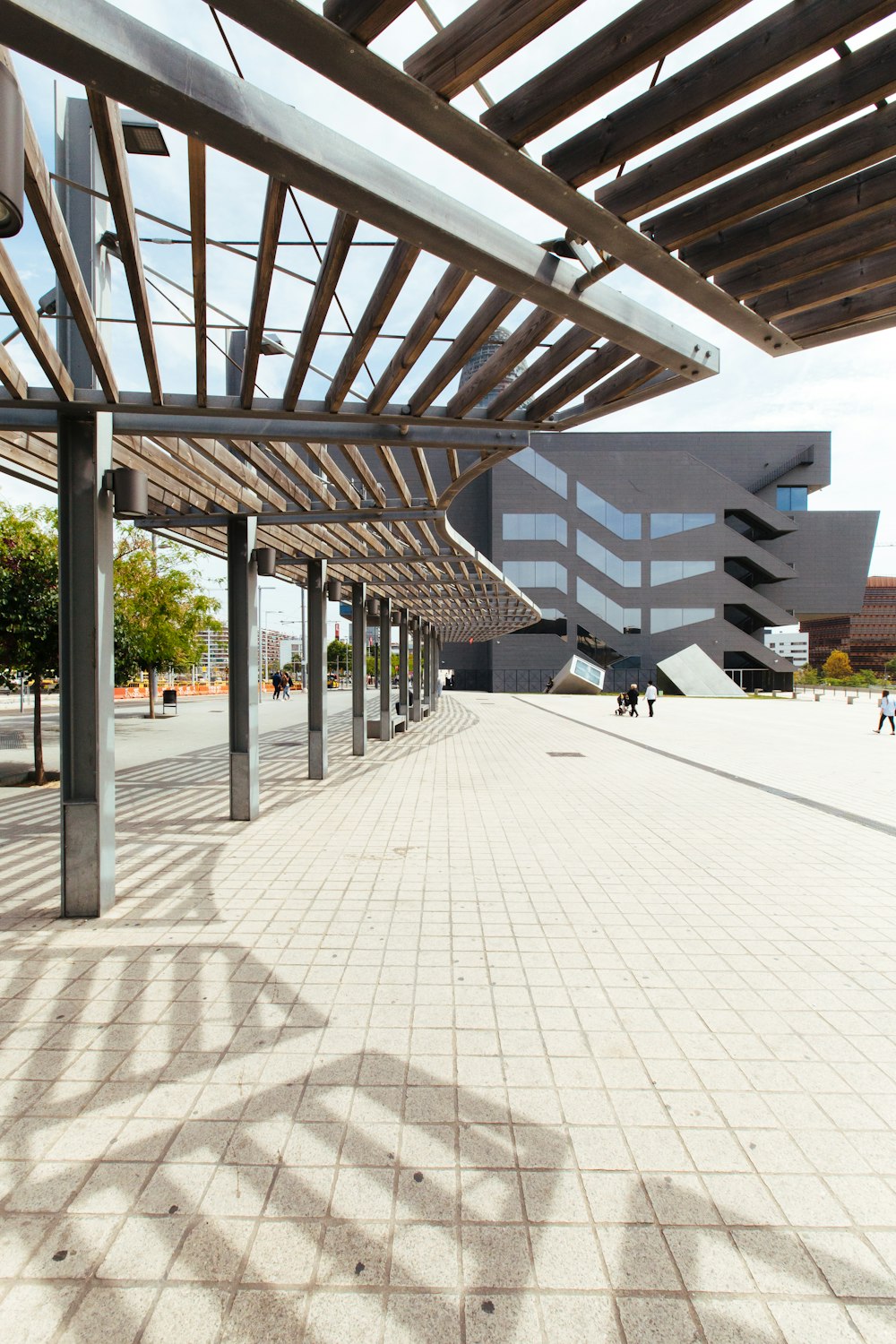 ein großes Gebäude mit einem Dach und einem Gehweg