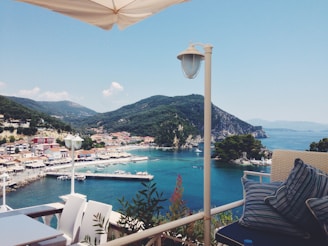 Seaside Sicilian apartment balcony overlooking calm turquoise waters and a colorful harbor