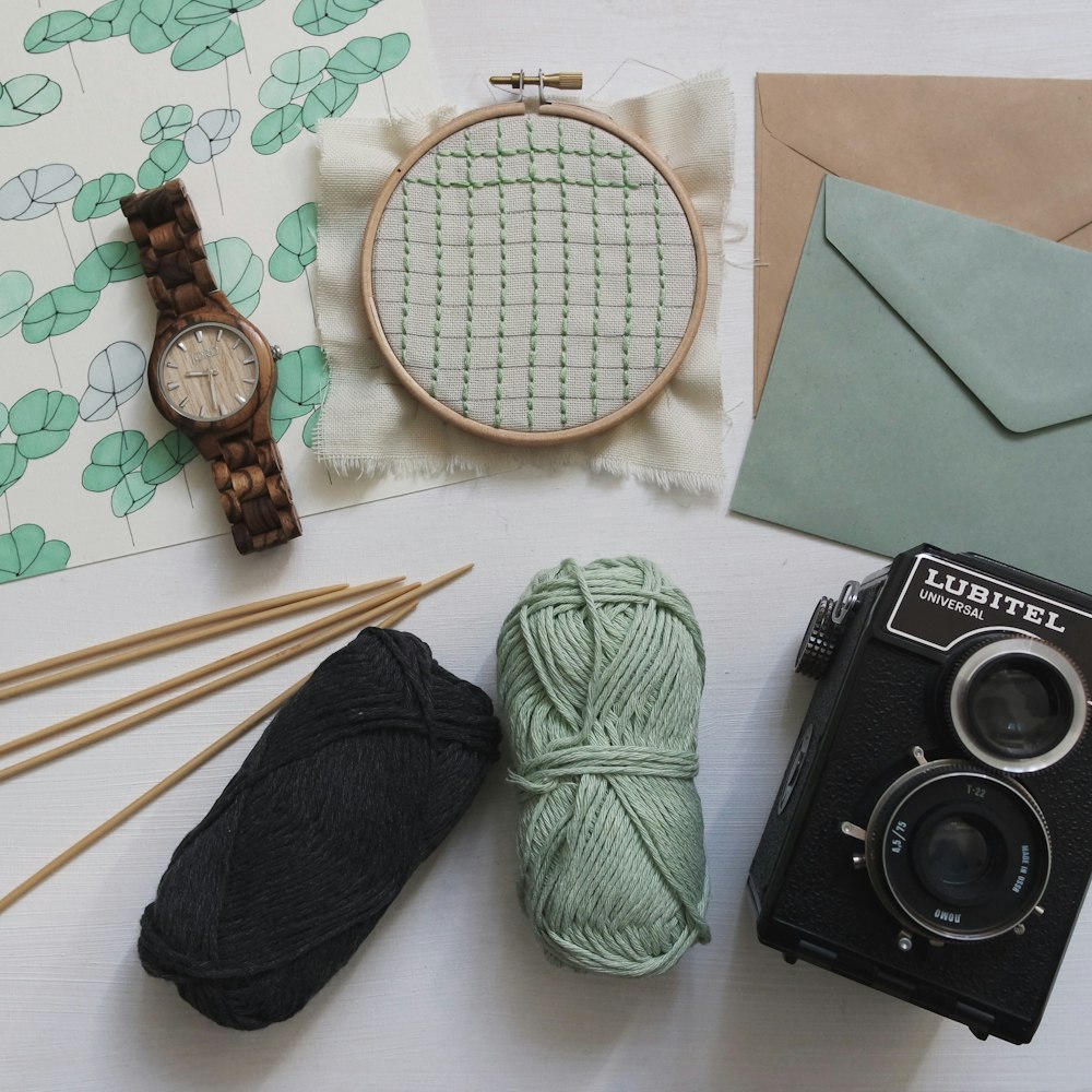green and black yarns with round brown watch and black Lubitel camera