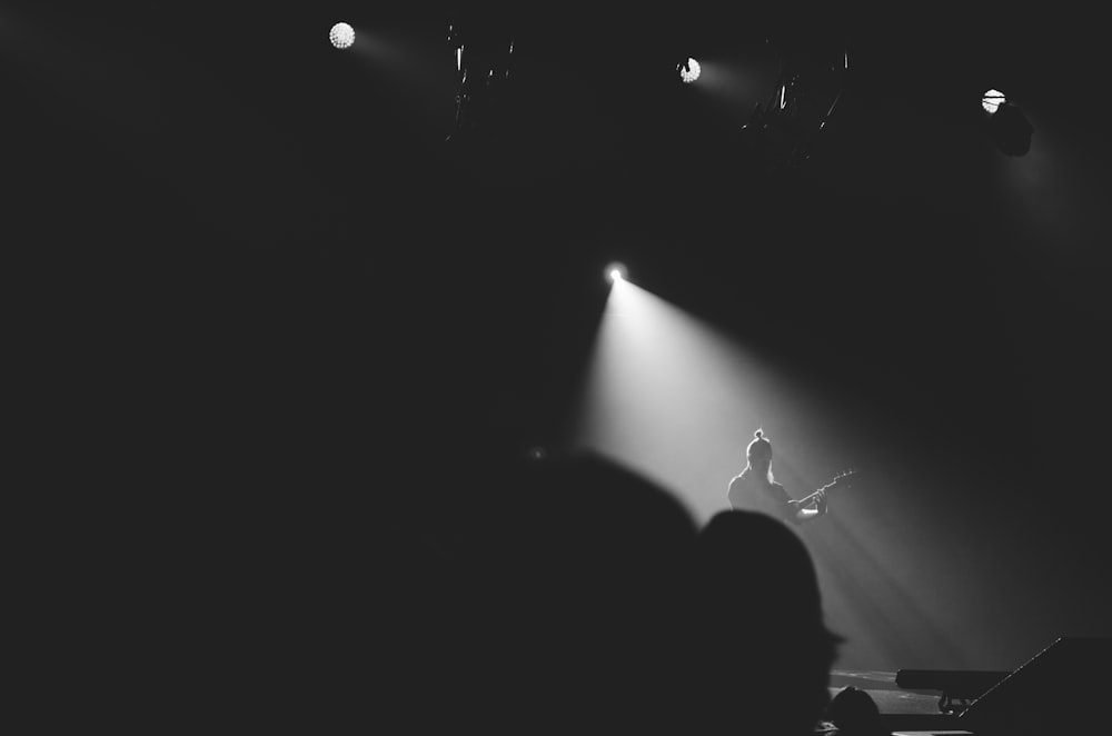 personne jouant de la guitare sur scène