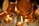 Hanging copper pots and pans, showcasing their polished surface and warm metallic hues. The focus is on the intricate details and reflections, with a soft background blur.