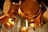 Hanging copper pots and pans, showcasing their polished surface and warm metallic hues. The focus is on the intricate details and reflections, with a soft background blur.
