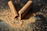 Close-up of hand sprinkling rich brown cinnamon powder over rustic wooden table.