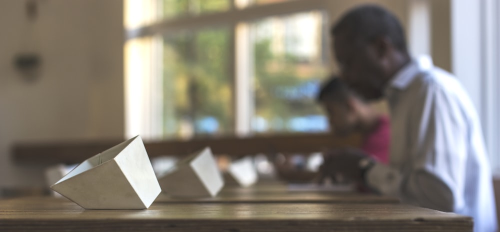 a man sitting at a table next to a white object