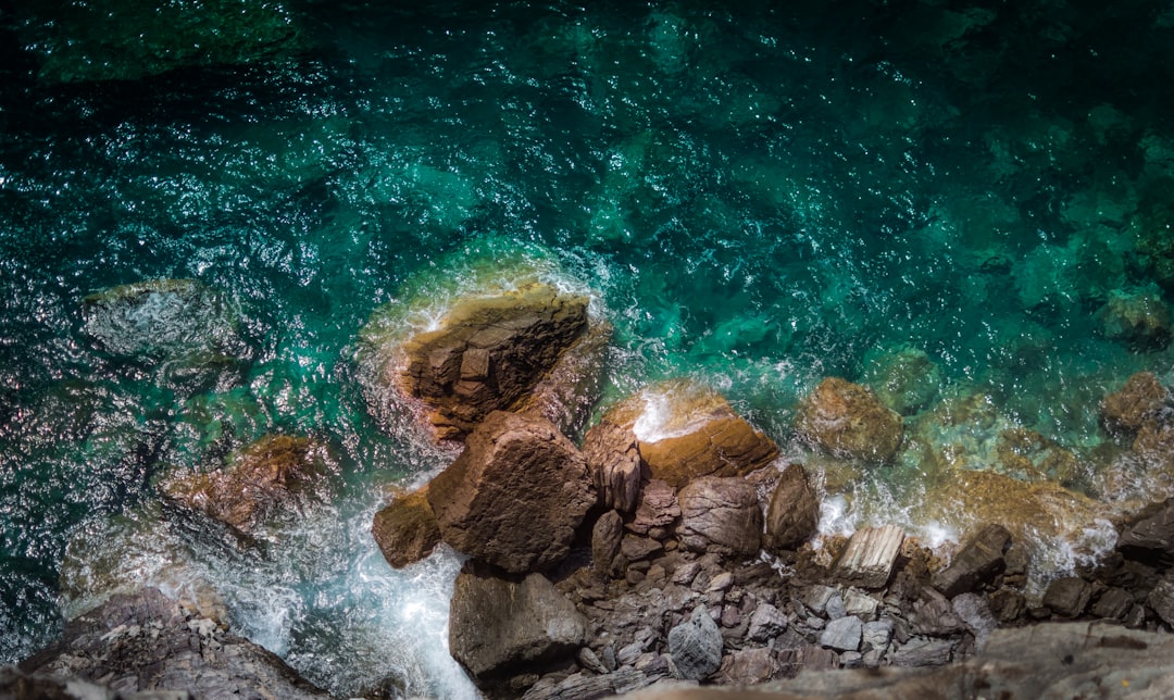 rocky shore near teal body of water