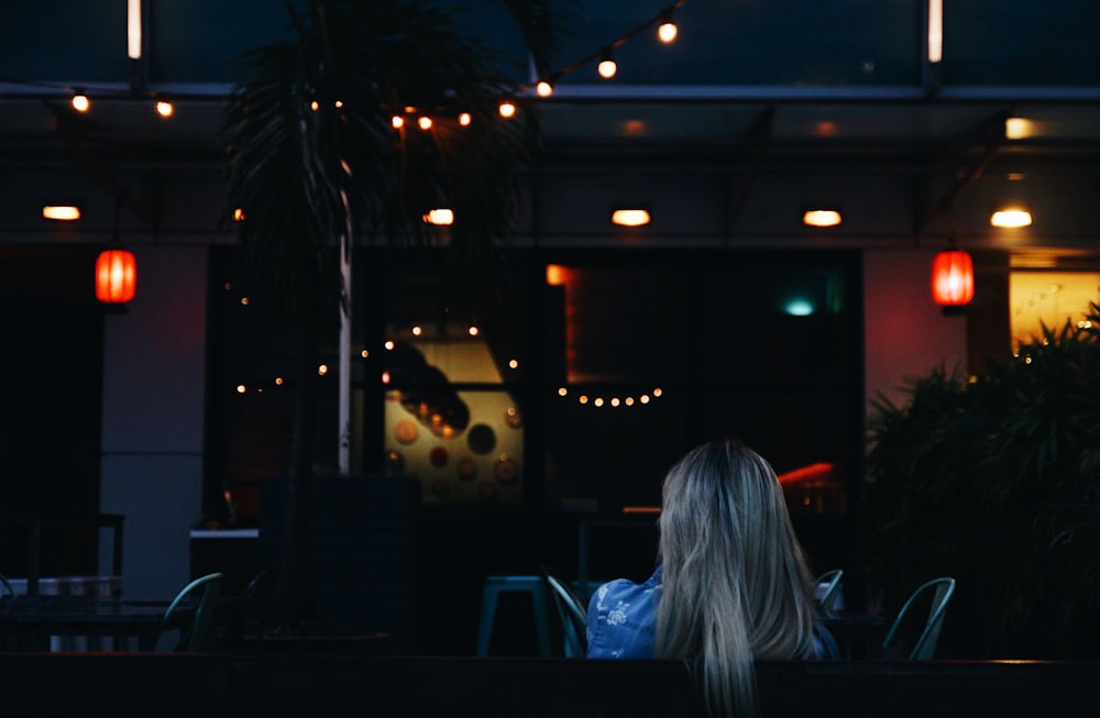 woman sitting while facing towards bar