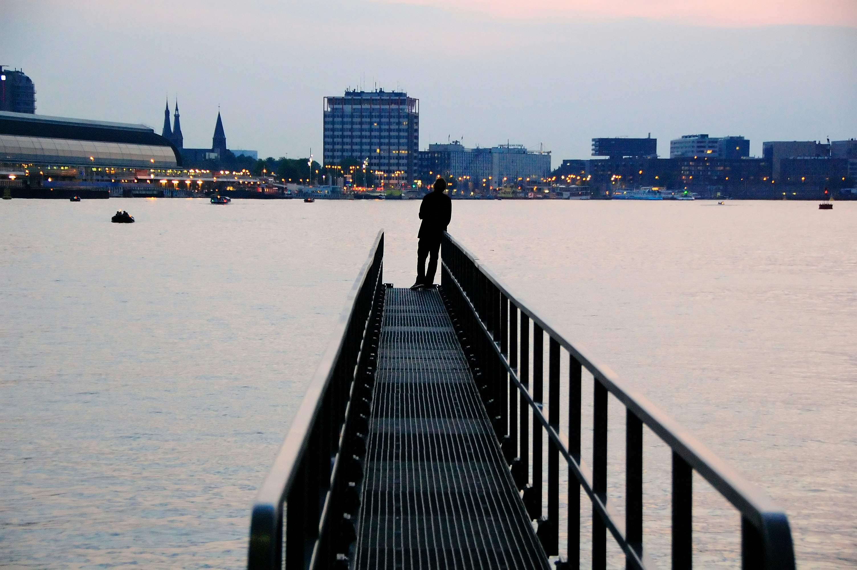 silhouette of person standing on metal dock