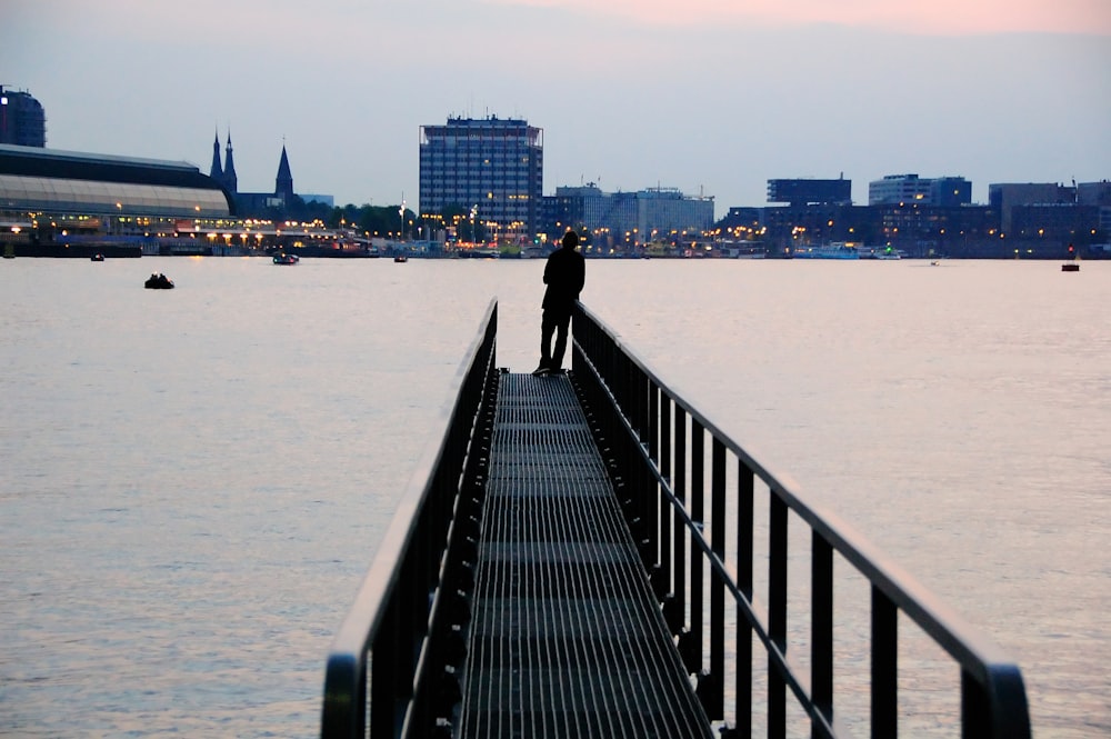 silhouette of person standing on metal dock