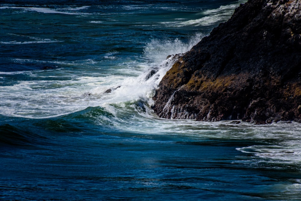 water wave hitting rock formation