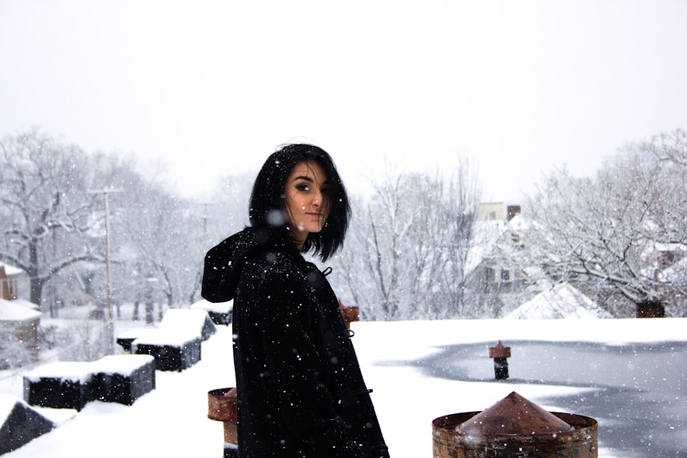 mulher vestindo camisa preta em pé sob o tempo de neve