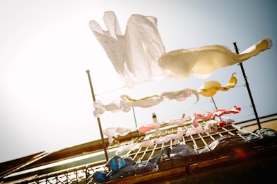 low-angle photography of hanging clothes outside house during daytime elevated teams background