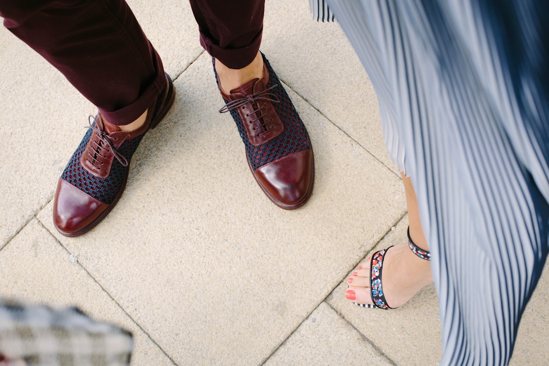 A man in brown leather shoes next to a woman in stylish sandals