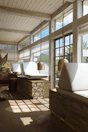 Natural stone flooring leading to a cozy lounge area with sand-colored cushions.
