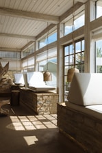 Hostel lounge area with muted sage cushions and natural light pouring in.
