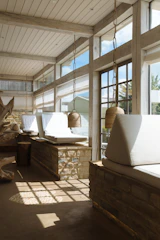 Natural stone flooring leading to a cozy lounge area with sand-colored cushions.