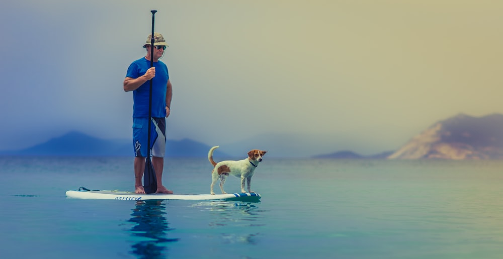A man and dog paddle boarding on a tranquil sea at Bananistas