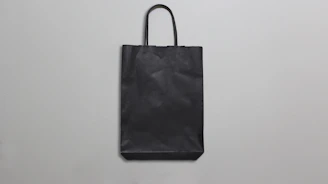 Golden-accented polypropylene bags arranged elegantly against a graphite gray background.