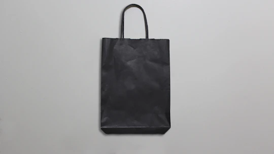 Golden-accented polypropylene bags arranged elegantly against a graphite gray background.