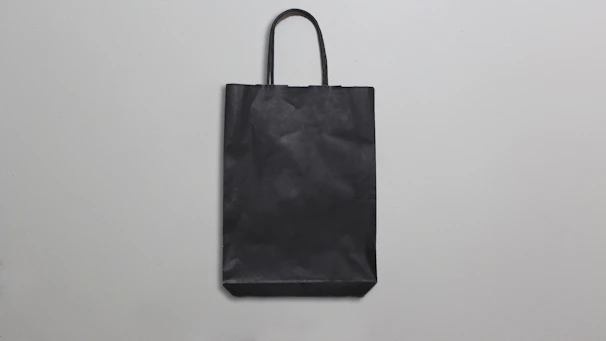 Minimalist illustration of a shopping bag with a price tag on a clean white background.