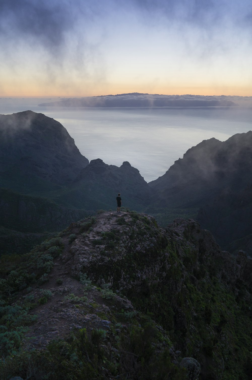 person standing on rock monolith