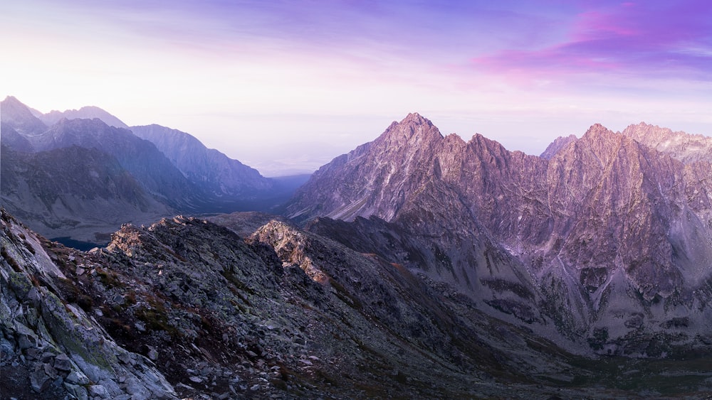 landscape photography of mountain ranges under purple and pink skies