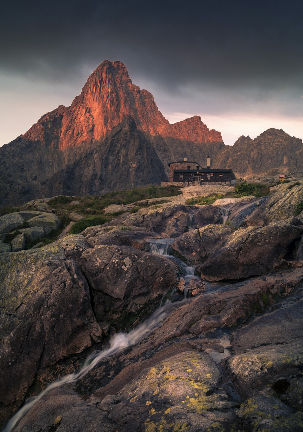 ゴールデンアワーの山前の黒い建物