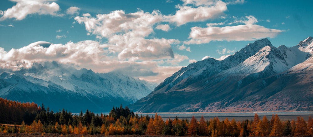 snow-capped mountain in the horizon with cumulus clouds