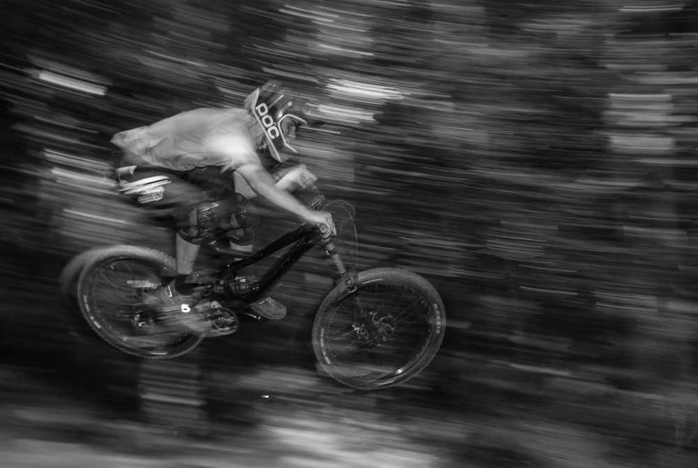 panning photography of man on bike doing stunts