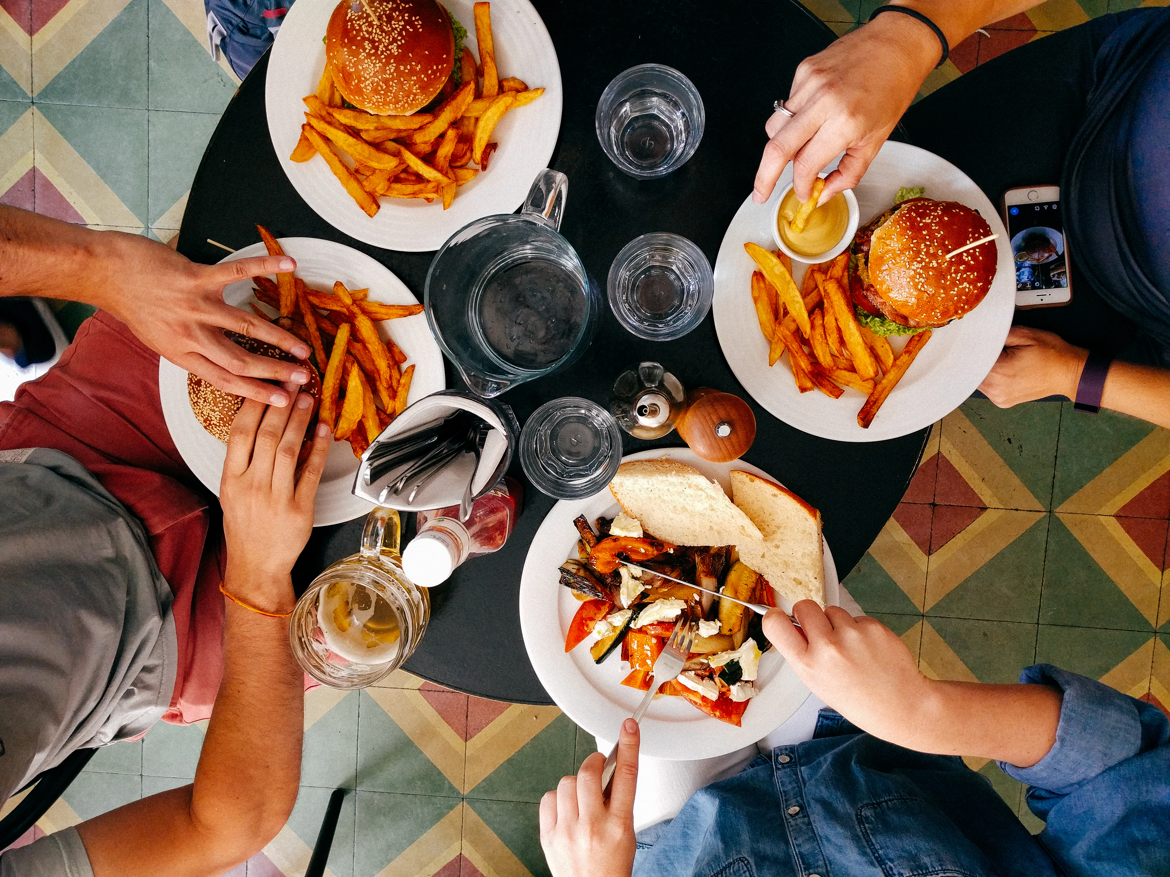 Image décorative représentant 4 personnes en train de manger des burgers autour d'une table