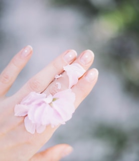 person with pink bow on hand selective focus photography