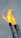 Bright orange flames are rising from the top of metal flare stacks against a cloudy gray sky.