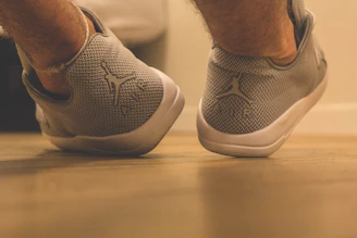 Close-up of stylish, comfortable casual shoes on a wooden shelf with warm lighting.