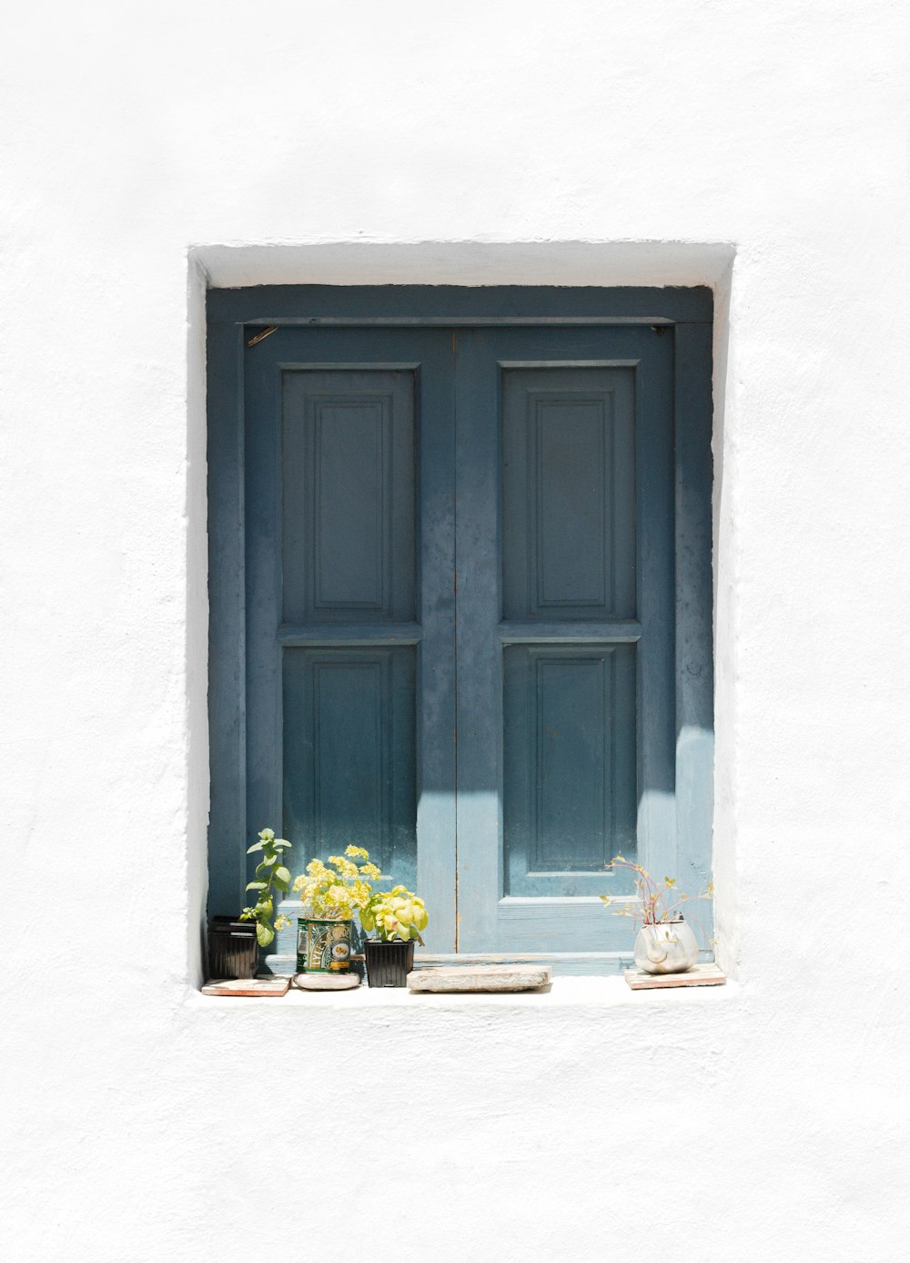 blue wooden door on white concrete wall